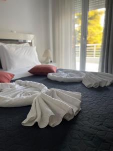 three white towels are laying on a bed at Giouli's Maison in Eretria