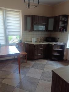 a kitchen with wooden cabinets and a tiled floor at Hostel Tet6 in Gdynia