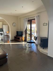 a living room with a chair and a television at Villa Balmoral in Peyia