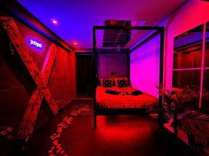 a bedroom with a bed with pink and purple lighting at Suite XOXO in Souppes-sur-Loing