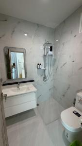 a white bathroom with a sink and a toilet at Sunrio Beach Hotel Sichon in Ban Plai Thon +122 photos