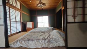 a bedroom with a bed in a room with windows at 天水島ヒルズ in Tokamachi +46 photos