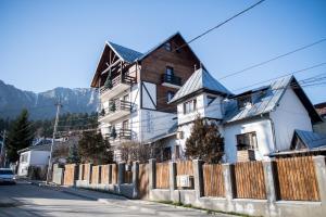 布什泰尼Camere de inchiriat Cascada的前面有栅栏的大白色房子