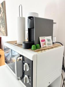 a microwave oven with a coffee maker on top of it at Le Tiny Studio in Saint-Denis +9 photos