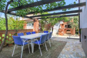 einen Tisch und Stühle unter einer hölzernen Pergola in der Unterkunft Apartments Aida in Poreč