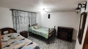 a bedroom with two beds and a dresser in it at Departamento Confortable in Latacunga +11 photos