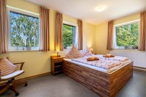 a bedroom with a bed and two windows at Gästezimmer - Meißen in Meißen