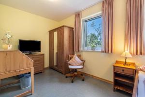 a bedroom with a desk and a chair and a television at Gästezimmer - Meißen in Meißen