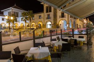 a restaurant with tables and chairs in front of a building at Hotel La Pinta in Palos de la Frontera