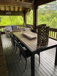 a wooden table and chairs on a wooden deck at Cozy log cabin in Geiranger in Geiranger