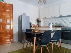 eine Küche mit Tisch, Stühlen und Kühlschrank in der Unterkunft Efi's House in Florina