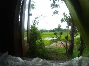 
a view through a fence of a grassy area with trees at Sukhothai City Resort in Sukhothai
