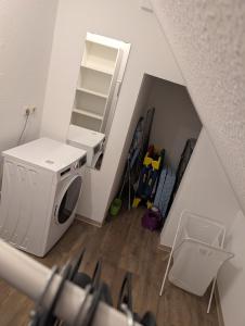 an attic room with a washing machine and a staircase at Pension Quartier 11 in Waren