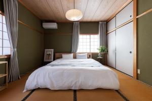a bedroom with a large bed and a large window at Ninifuni Kanazawa in Kanazawa