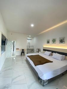 a large white bedroom with a large bed in it at Kims Stay Syariah in Jember