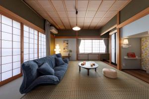 a living room with a blue couch and a table at Ninifuni Kanazawa in Kanazawa +54 photos