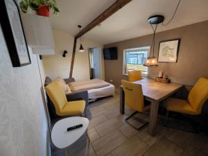 a living room with a table and yellow chairs at Ferienapartment MIA in Fritzlar