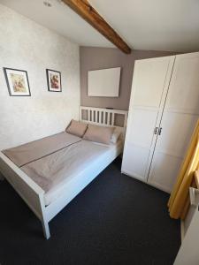 a bedroom with a bed and a large white cabinet at Ferienapartment MIA in Fritzlar