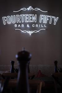 a neon sign that reads fourteen fifty bar and grill at Ski Rider Hotel in Kalkite +38 photos