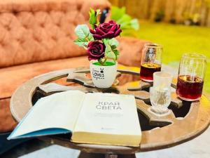 a table with a book and two glasses of wine at Calm Night Surf Stay in Arugam Bay
