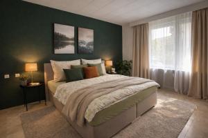 a bedroom with a large bed and a green wall at Bollenhut 1 in Bad Wildbad