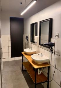 two sinks in a bathroom with two mirrors at Ayni Living - Hostel in Lima +75 photos