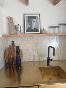 a kitchen counter with a sink and a picture of a woman at De groene salon in Broek in Waterland +20 photos
