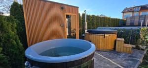 a bathroom with a tub and two trash cans at Mielnova Adults Only Jacuzzi & Sauna Apartamenty in Mielno