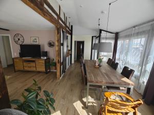 a dining room with a wooden table and a tv at Apartment Rose in Fritzlar
