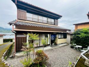 a small house with a balcony on top of it at 港の魚宿 おおそね in Owase