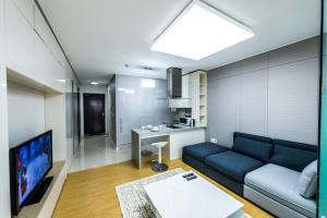 uma sala de estar com um sofá azul e uma cozinha em The Аddress Highvill 1 em Astana