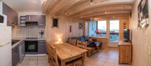 a kitchen and living room with a wooden table and chairs at Immeuble le Champsaur in Orcières