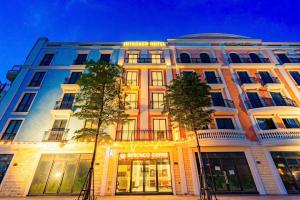 a large building with trees in front of it at Intechco Hotel S1-25 sầm Sơn in Sầm Sơn