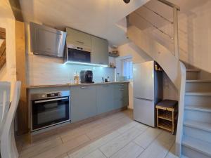 a kitchen with stainless steel appliances and a staircase at La vallée de la bruche in Wisches