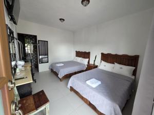 a hotel room with two beds and a mirror at Hotel Magnolia cuetzalan in Cuetzalán del Progreso