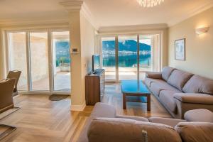 a living room with a couch and a tv at Villa Olivia in Kotor