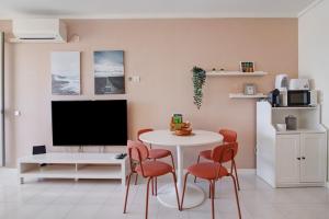 a living room with a table and chairs and a tv at Algarve Vilamoura Apartment in Quarteira