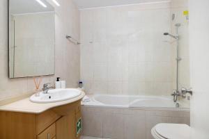 a bathroom with a sink and a tub and a toilet at Algarve Vilamoura Apartment in Quarteira