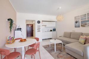 a living room with a couch and a table and chairs at Algarve Vilamoura Apartment in Quarteira +17 photos