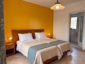 a bedroom with a bed with a yellow wall at Garni Viggiona in Trarego