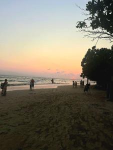a group of people standing on a beach at sunset at S And K Holiday Stay in Beruwala
