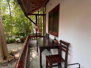 a porch of a house with a wooden table and chairs at Pagi Pagi villas in Ao Nang Beach