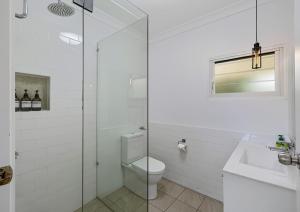 a bathroom with a toilet and a glass shower at Classic Beach House on Surfside - Pet Friendly in Pottsville +12 photos