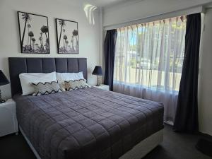 a bedroom with a large bed and a large window at Kiama Motel 617 in Kiama