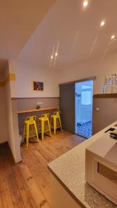 a kitchen with yellow stools and a bar in a room at Apartments Kolo 77 in Berlin