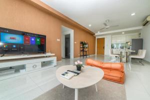 a living room with a couch and a table and a tv at Teega Residence near Puteri Harbour Iskandar Puteri by Our Stay in Nusajaya