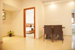 a dining room with a table and a bedroom at Blue Vista Residency in Kalpetta