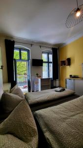 a bedroom with two beds and a desk and windows at Apartments Kolo 77 in Berlin