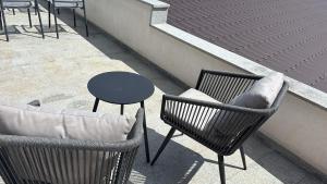 a balcony with two chairs and a table and a table at Panorama House Opatija in Donji Rukavac