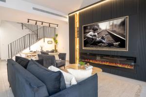 a living room with a large tv hanging above a fireplace at אחוזת אבישג - וילה יוקרתית עם בריכה מחוממת וממ"ד למשפחות in Shelomi